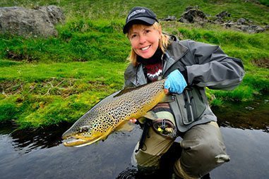 Cathy smiling with her large, brown trout!