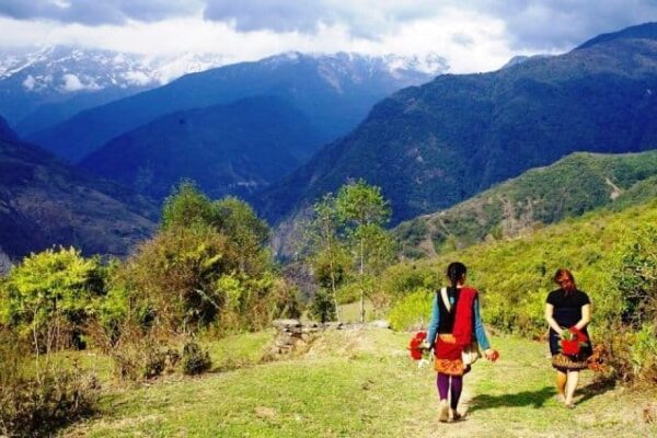 Two young gurung Buddhist villagers walking home after collecting Laliguran blossoms from a mountainside near Pokhara.