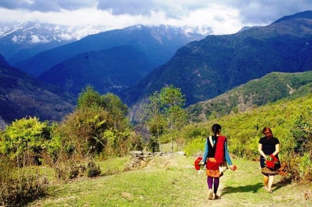 In Praise of Walking 1 Two young gurung Buddhist villagers walking home after collecting Laliguran blossoms from a mountainside near Pokhara.