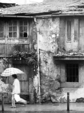 Woman walking in the rain on a Sunday in Lugo, Galicia in Spain