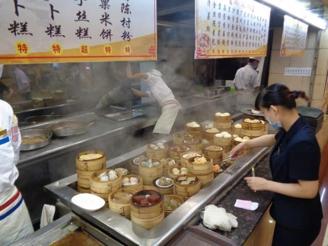 The hotel staff prepare an array of breakfast dishes, including jiaozi, sweet pork buns and chicken feet.