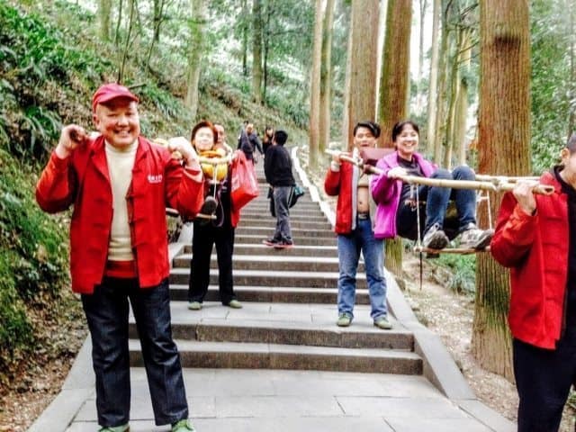 Tourists and locals being carried down the trail in these unique contraptions. 