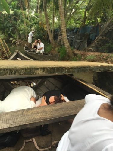 Crouching on the floor of the boat.