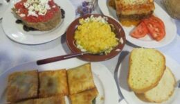 Assorted mezedes, including dakos, fava beans, moussaka and kalitsounia, pies filled with local greens.