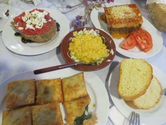 Crete: A Food Journey Across the Island 3 Assorted mezedes, including dakos, fava beans, moussaka and kalitsounia, pies filled with local greens in Crete.