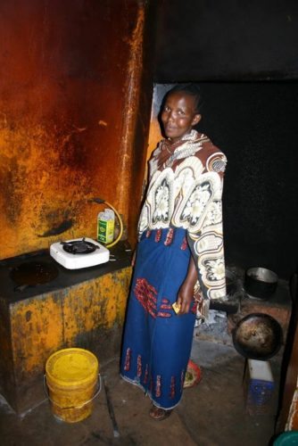 Tanzania. A woman shows off her modest kitchen.