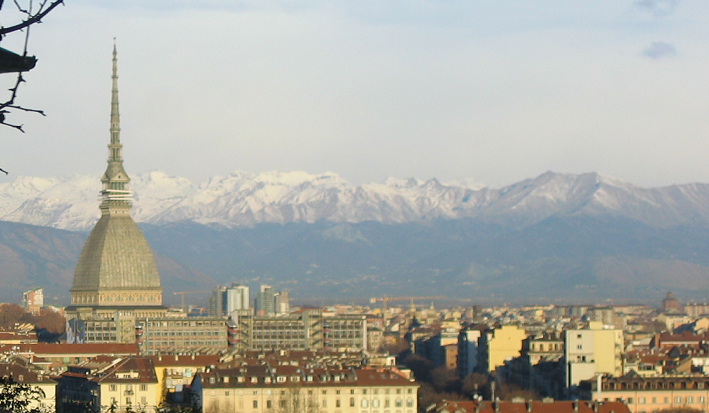 The city's skyline features the distant Alps.