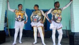Participants waiting for paint to dry during Pullikali Festiva at one of 7 different place as in the