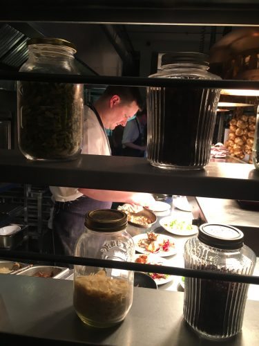 A chef prepares a small plate at Evelyn's Cafe, a cozy restaurant in the Northern Quarter, filled with music clubs and nightclubs.
