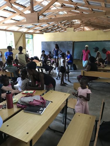 In a makeshift medical clinic in Leogone, Haiti, helping local residents with treatments.