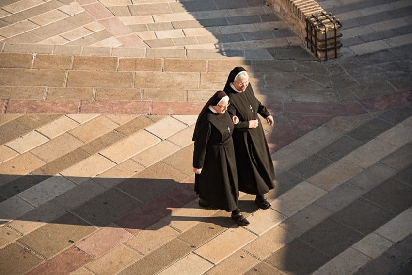 Arm in arm, as likely long time friends, these nuns are headed to worship at the St. Francis of Assisi Cathedral.