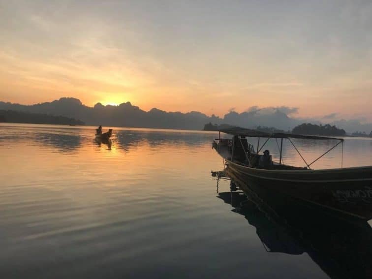 The sun rises over the mountains near Chiaw Laan Lake, Thailand. | GoNOMAD Travel The sun rises over the mountains near Chiaw Laan Lake, Thailand. | GoNOMAD Travel