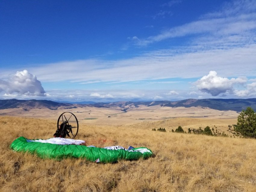 A Paramotor Having Just Landed, Unbuckling His Chute.