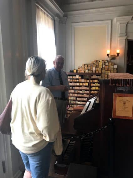 A docent discussing the different scrolls for the organ inside the Lincoln family home. 