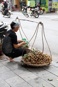 A vendor with her le thung at rest.