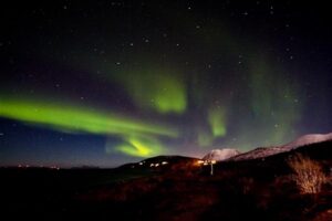 Wine and dine by the fireplace - with a little photography - and the northern lights over the fjord at Lyngen Experience.