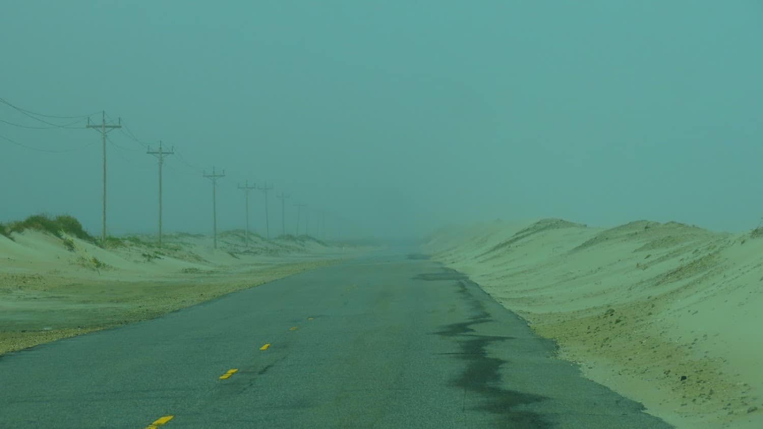 desolate road encroaching beach