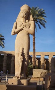 An imposing granite statue of the great pharaoh Ramses II, with one of his daughters at his feet, guards the entrance to the Hypostyle Hall.