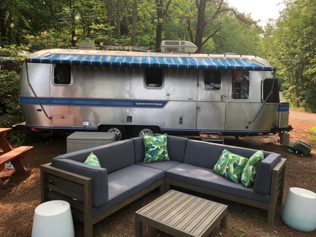 Airstream site One of the sites at Sandy Pines is an old Airstream trailer with outdoor furniture around a firepit.