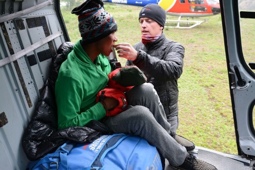 Global Rescue. Helping a passenger get into a helicopter.