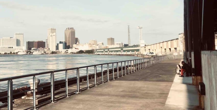 A musician plays the Melodica from Crescent Park, overlooking the New Orleans Central Business District skyline