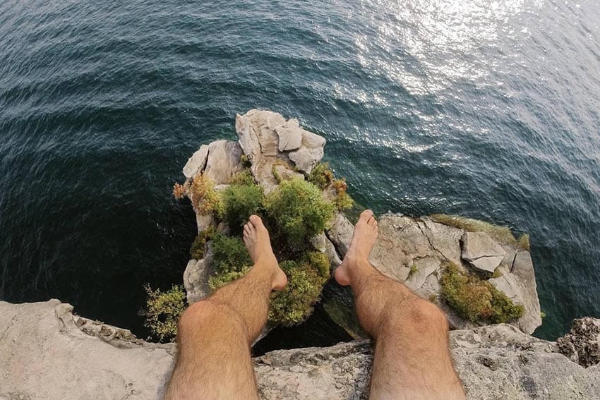 "No shirt, no shoes, less problems. Catching our breath above trees growing off an outcropping over 50 feet below."