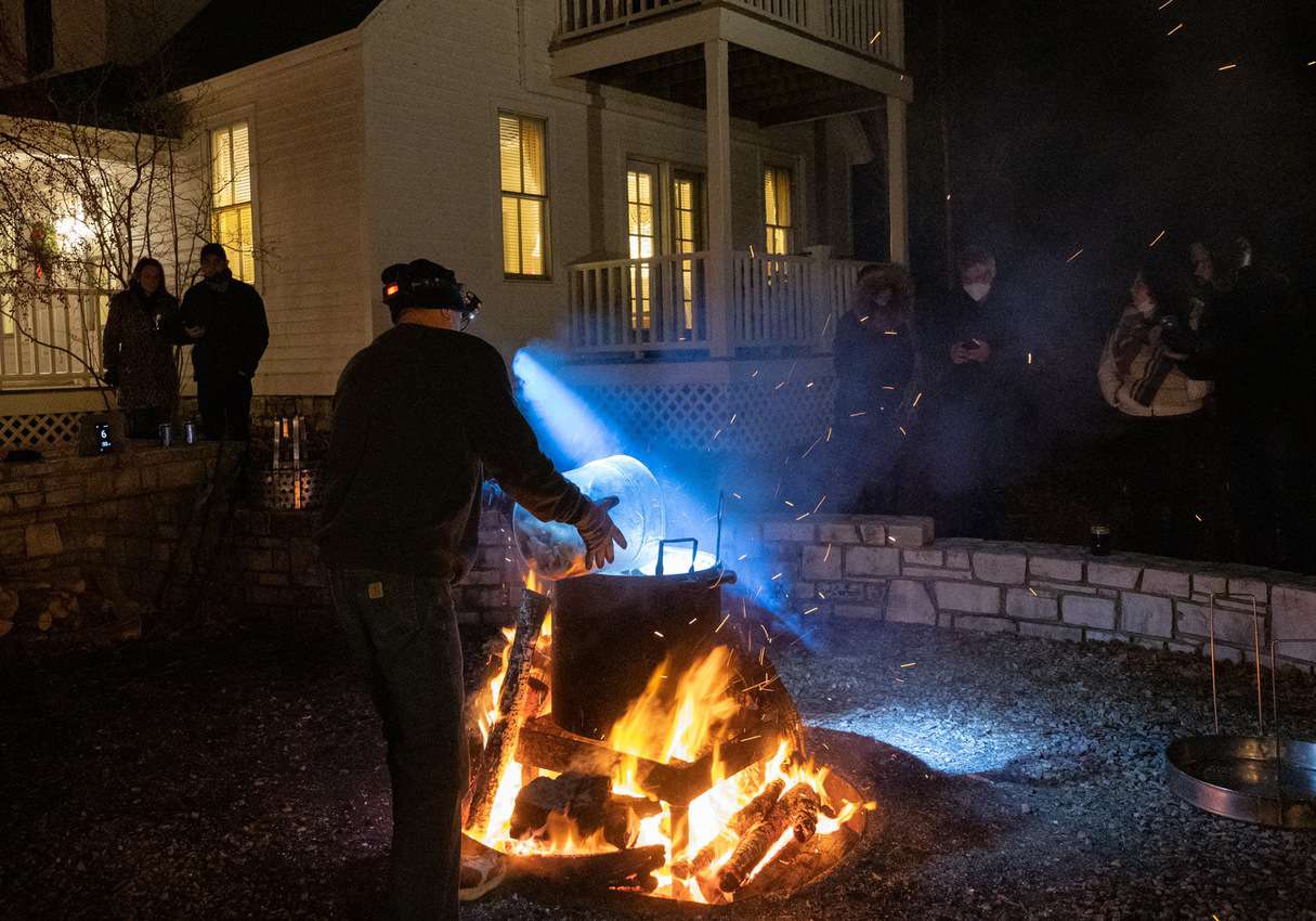 Pat McMurty, the boil master at White Gull Inn, dumps a bucket of whitefish chunks into a kettle of boiling water.