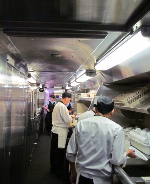 Fancy footwork and cooperation are the order of the day in the small galley that turns out dozens of meals at each sitting Photo Debra Smith