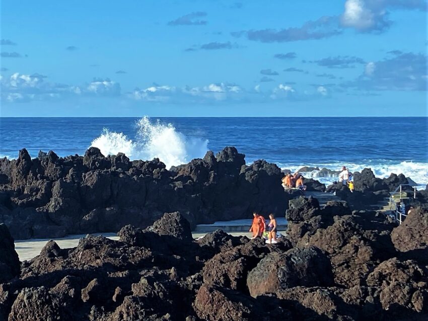 Waves crash against the volcanic rocks surrounding the fabulous Biscoitos natural swimming pools where locals and visitors like to wade and swim off the coast of Terceira Island, Azores, Portugal.