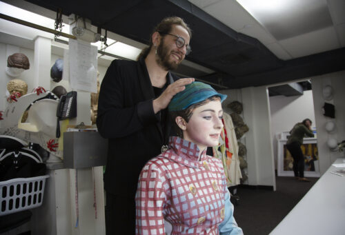 Costume designer backstage at Pageant of the Masters fits a volunteer actor with a headpiece. Photo credit Christopher Allwine.