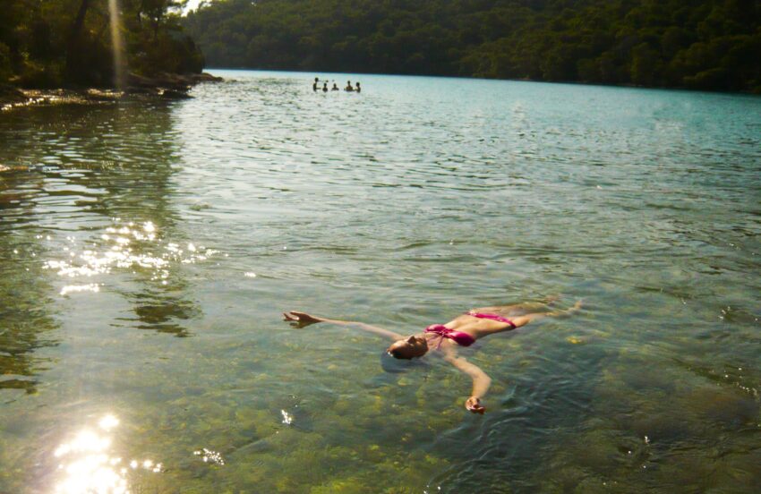 Woman floating in Malo Jezero (Small Lake) in Mljet National Park Croatia.