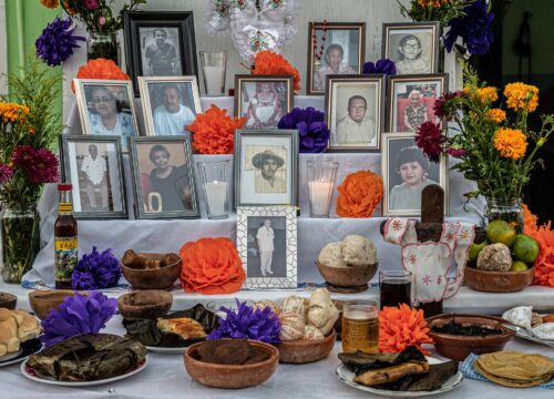 Ofrendas (alters) set up by families either in their homes or at grave sites are filled with food, drink, candles, flowers, and photos of the deceased.