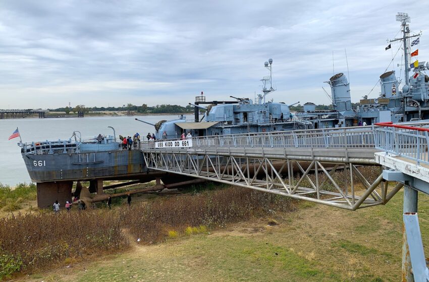 The USS Kidd sits high and dry during unusually low Mississippi River in Baton Rouge as people walk beneath the WWII destroyer.