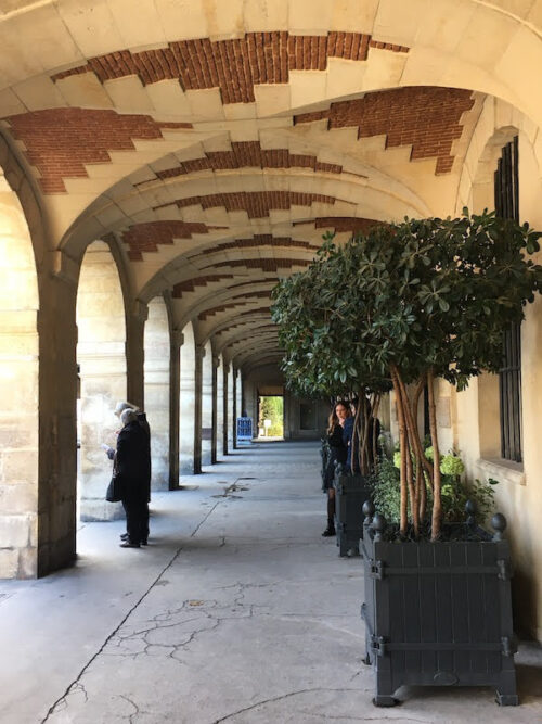 The doorway to a "secret garden" at the end of an arcade in the Place des Vosges