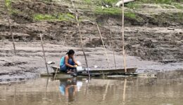 A woman washing cookware in the Amazon