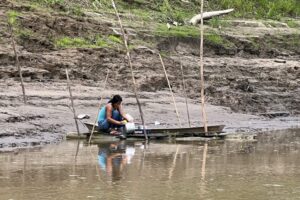 A woman washing cookware in the Amazon