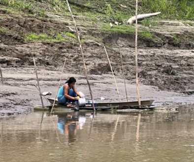 A woman washing cookware in the Amazon