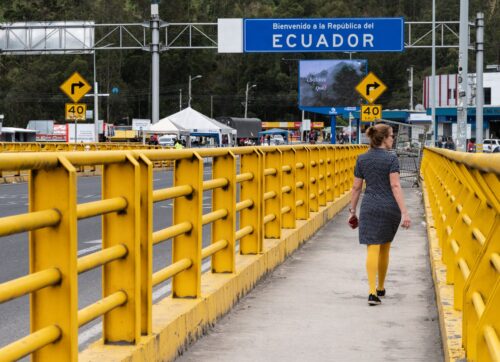 A bright yellow bridge over a deep chasm marks the border crossing between Colombia and Ecuador.