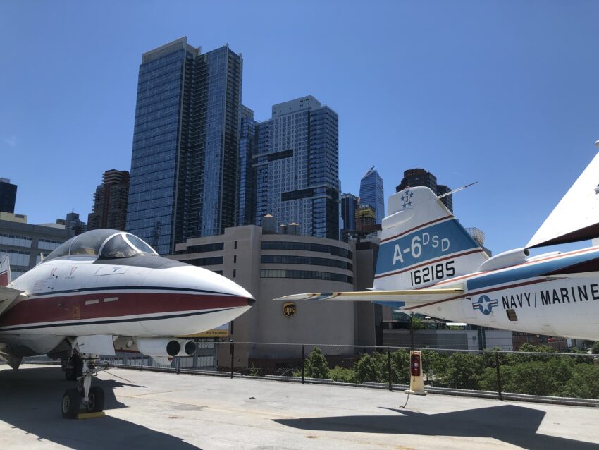 The display of military planes on the deck of the Intrepid with city views in the background