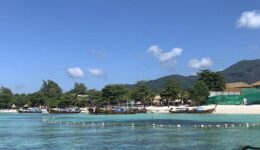 The crystal-clear waters and powdery sand of Pattaya Beach as seen from coming onshore on a longtail boat.
