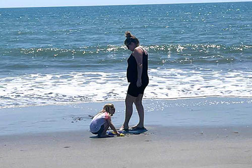 A mom and daughter play in the sand at Holden Beach, named one of the top 10 beaches for families by National Geographic Traveler.