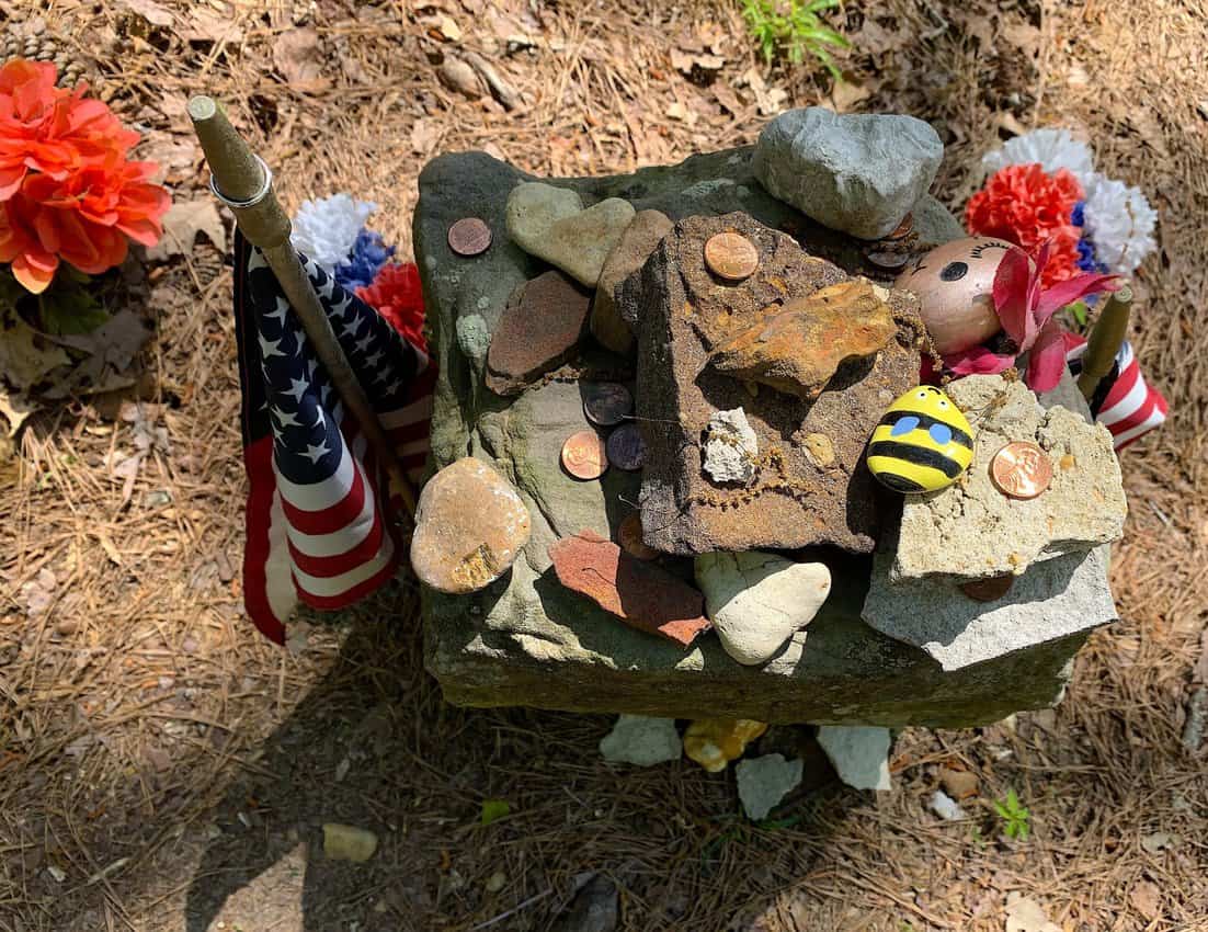 Troop’s grave in the Coon dog cemetery is decorated with coins, stones and other items.