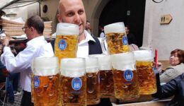 Professional waiters delivering tankards of beer.