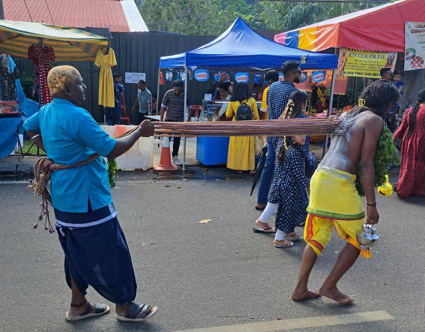 A procession where a man was hooked into the flesh in his back and pulled by another man from behind as an act of devotion to the Hindu god Murugan