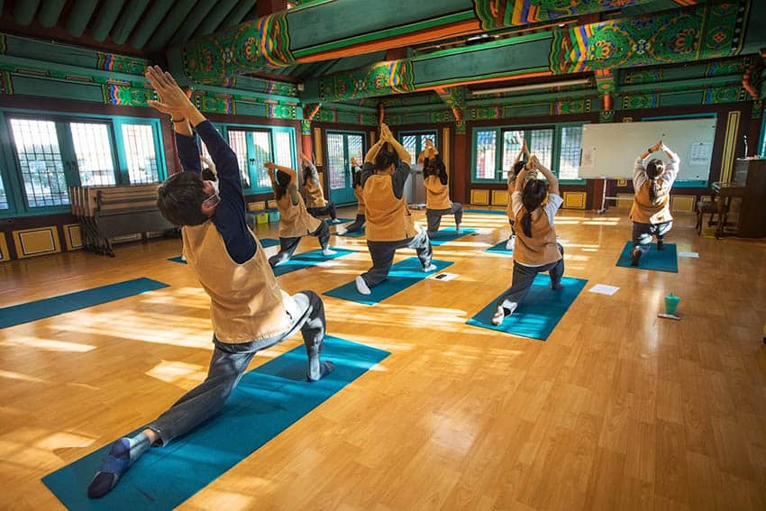 Zen and Temple Stays in South Korea 9 At Jeungsimsa Temple's yoga session, participants engage in stretching routines (Photo by Cultural Corps of Korean templ Buddhism) Temple Stays