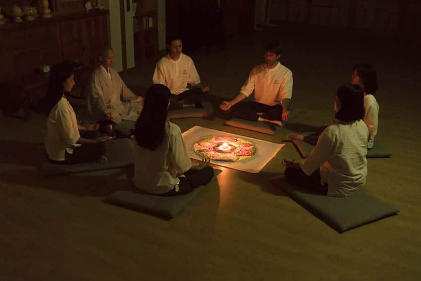 Zen and Temple Stays in South Korea 11 Participants form a circle around a candle in meditation (Photo by Cultural Corps of Korean Buddhism)