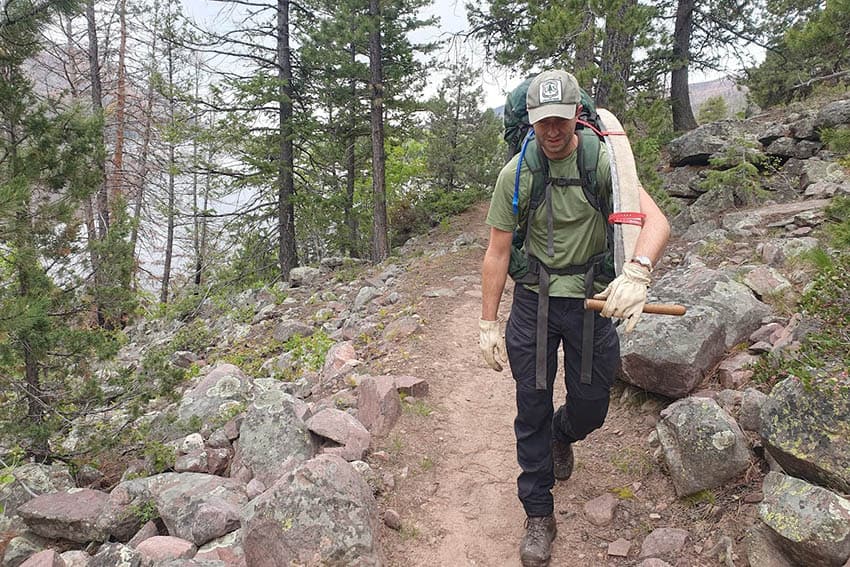 Carrying a two man crosscut saw along the Lake Fork Trail, High Uintas Wilderness, UT.