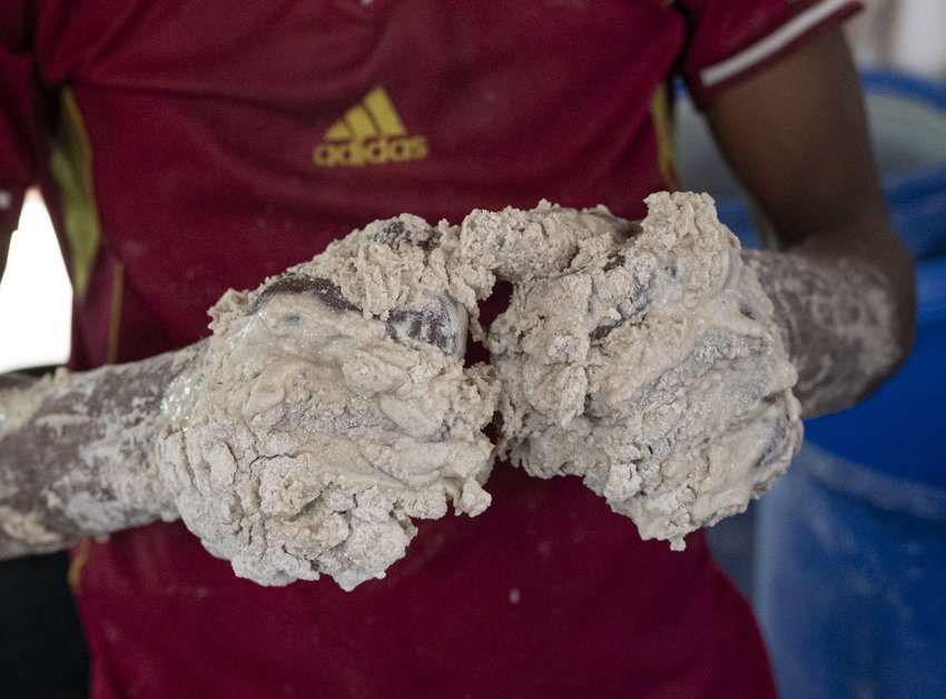 These hands are busy mixing teff flour, water, and starter in a huge vat to make injera, an Ethiopian flatbread. Injera functions as an eating utensil for scooping up stews, vegetables, salads, and sauces.