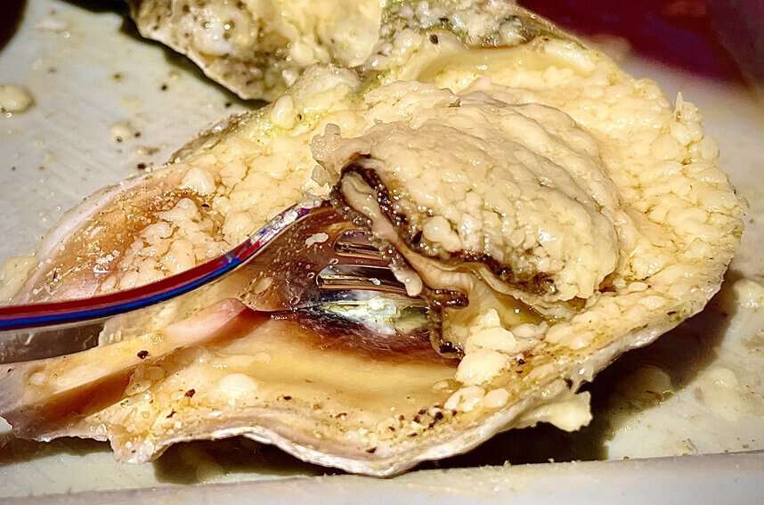 Panama City Beach's Top Shuckers 3 PCB Oysters at Shuckum's are baked with butter and garlic and topped with a generous sprinkle of Parmesan cheese.