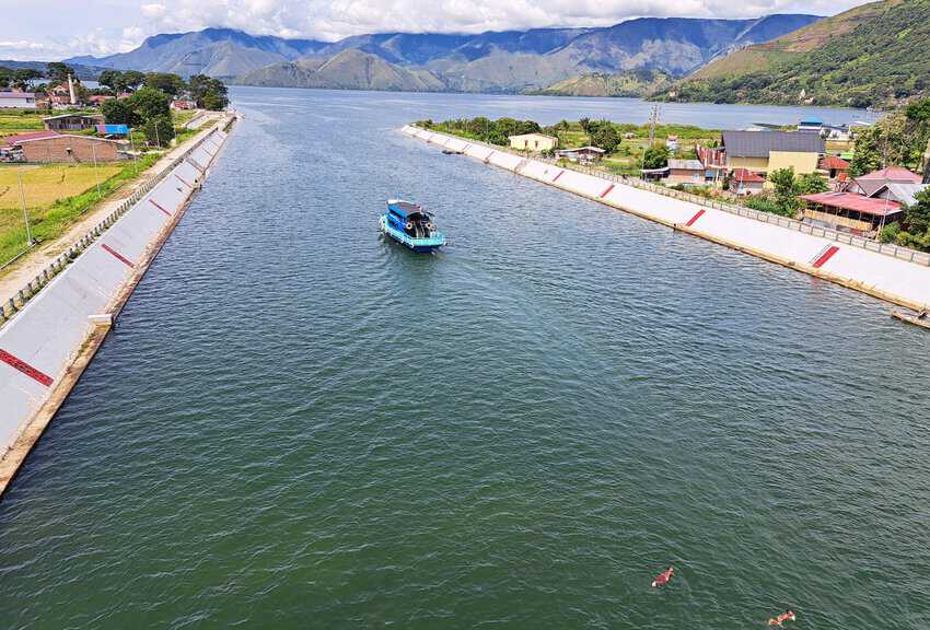 Lake Toba Indonesia: The World's Largest Crater Lake 9 Village children swim in the canal below Aek Tano Ponggol Bridge